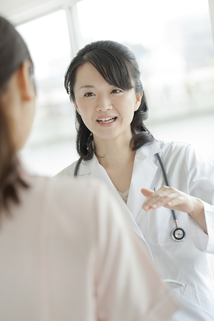 不正出血と腰痛があり診察を受ける女性